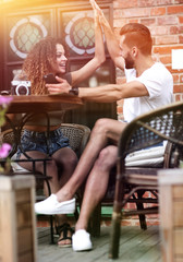 Plakat Portrait of a young couple sitting down at a cafe terrace