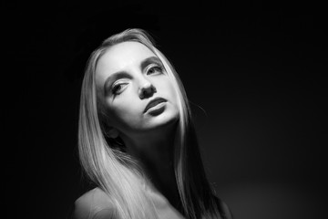 Portrait of a beautiful blonde on a black background.