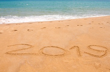 Written year 2019 on sand beach at the sea.