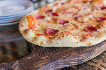 close up of pepperoni pizza on wooden desk, selective focus