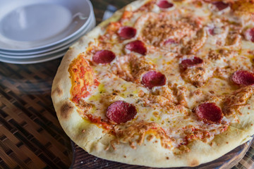close up of pepperoni pizza on wooden desk, selective focus