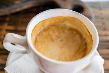 close up of white cup of cappuccino on table