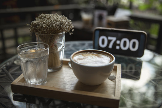 Cup of coffee with hot latte art in cafe shop or restaurant at 07.00 o'clock