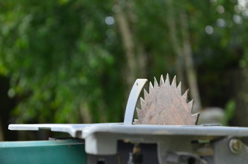 A disk of electric saws with a triangular tooth on a background of nature.