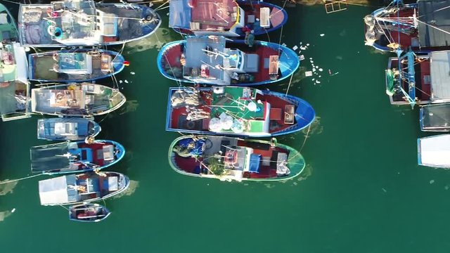 Aerial top down view traditional fishing vessels boats or ships used to catch fish in the sea these vessels are located at Trapani port in Italy Sicily showing the beautiful mediterranean blue ocean