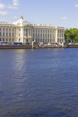 Fototapeta na wymiar A view of the historical building of the Academy of Arts and the University Embankment on the Neva River on a summer sunny day in St. Petersburg in Russia.