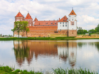Fototapeta na wymiar Mir, Belarus. Castle Complex Mir On Sunny Day with blue sky Background. Old medieval Towers and walls of traditional fort from unesco world heritage list