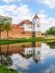 Naklejka na ściany i meble Mir, Belarus. Castle Complex Mir On Sunny Day with blue sky Background. Old medieval Towers and walls of traditional fort from unesco world heritage list