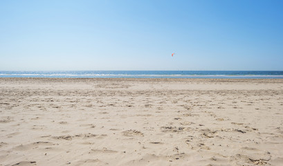 Fototapeta na wymiar Kitesurfing on sea along the beach in sunlight in summer