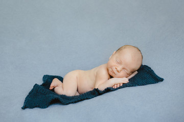 The small baby lies on the carpet