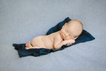 The small baby lies on the carpet