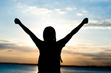 Fototapeta premium Woman silhouette standing alone in sunset scene,beautiful sky in the evening.