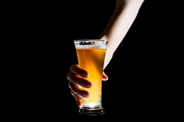 Foto auf Leinwand Hand holding glass of craft beer on black background © joesayhello