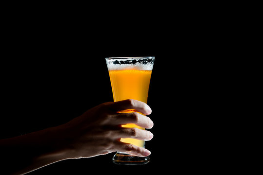 Hand Holding Glass Of Craft Beer On Black Background