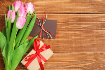tulips with a gift on a wooden table