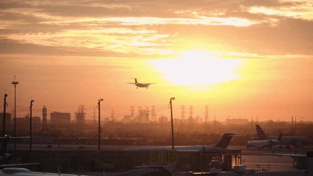 Silhouette of a commercial airplane landing on an airport at a beautiful golden sunset. 4k