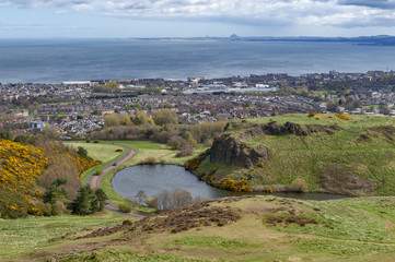 Fototapeta na wymiar View of Edinburgh city towards coastal area of the North Sea from Arthur’s Seat, the highest point in Edinburgh located at Holyrood Park, Scotland, UK