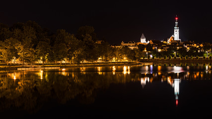 Fototapeta na wymiar Historic Tabor city and Jordan pond. Night view. South Bohemia, Europe. Beautiful skyline of the illuminated Hussite town center. Gothic church tower, waterfront and mirroring on water surface.