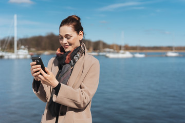 Smiling happy woman reading a text message