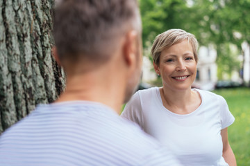 Obraz premium Attractive smiling woman chatting to a male friend