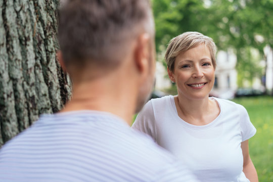 Attractive smiling woman chatting to a male friend