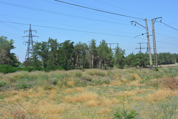 Blue sky with black electric wires over the railway, electricity supply to the city, power lines