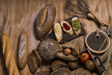 French baguette,cherry sauce,banana,kiwi fruit,eggs, wheat bran,chocolates,chia Seed and flour on wood.Copy space.