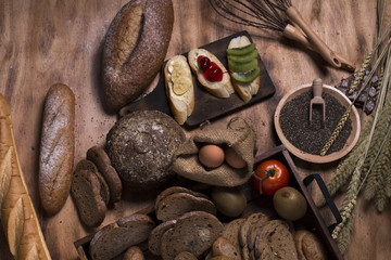 French baguette,cherry sauce,banana,kiwi fruit,eggs, wheat bran,chocolates,chia Seed and flour on wood.Copy space.
