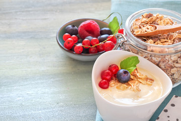 Yogurt with muesli and berries, healthy dessert on neutral background