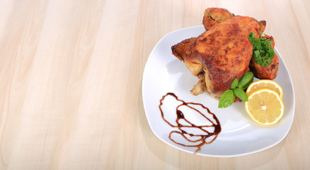 Kurczak pieczony z grila na białym talerzu.