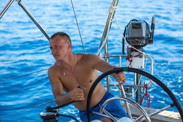 Men on the yacht during the sail races in the sea. Sailing and extreme sports.