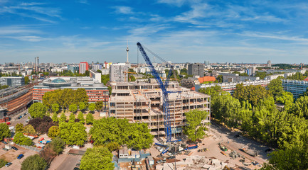 View from above on construction site with crane, television tower on Alexanderplatz and Berlin city...