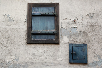 Alte Fenster- und Fensterläden an einer verfallenen Fassade eines Dorfes im Elsass