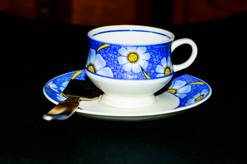 Single coffee cup on the plate with spoon