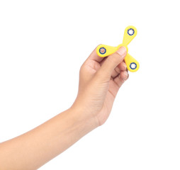 fingers playing a yellow fidget spinner isolated on a white background