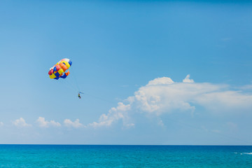 Couple of tourists flying on a colorful parachute