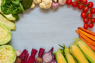 Food background with copy space for text. Fresh organic vegetables on the gray table: cherry tomatoes, zucchini, beet, garlic, cabbage, cauliflower, basil leaves, onion. Cooking concept. Top view