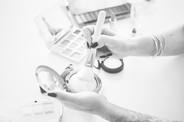 Hand holding a brush and cosmetics