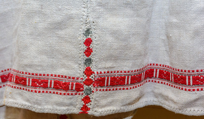 A fragment of ancient authentic embroidery on the hem of a woman's shirt.