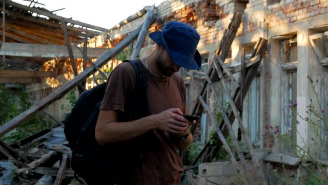 Ranger finds the way on mobile maps in ruins of a building close-up