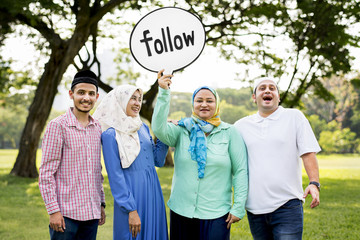 Muslim family holding up a follow sign