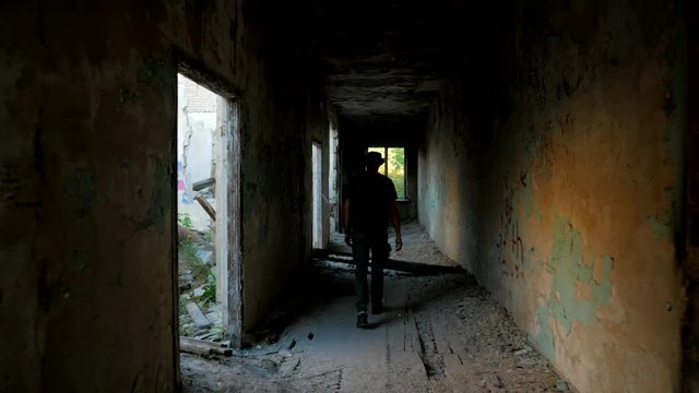 Tourist walks around ruins of a building in corridor