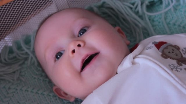 2 month old happy baby boy talking and making noise in his crib. Wearing a cute winter outfit.
[link]https://www.pond5.com/stock-footage/20476165 Click here to see close up of the same thing[/link]