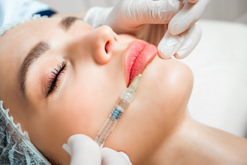 The doctor cosmetologist makes the Rejuvenating facial injections procedure for tightening and smoothing wrinkles on the face skin of a beautiful, young woman in a beauty salon.Cosmetology skin care.