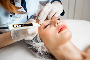 The doctor cosmetologist makes the Rejuvenating facial injections procedure for tightening and...