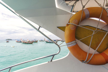 Orange lifebuoy hanging on stern railing of speed boat