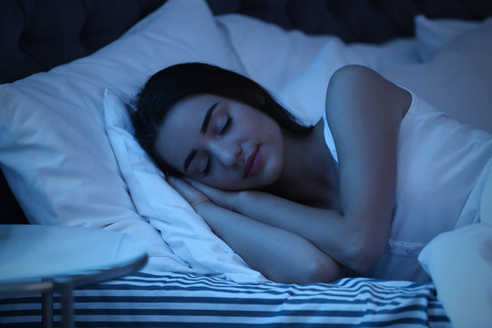 Young woman sleeping in bed at night. Sleeping time