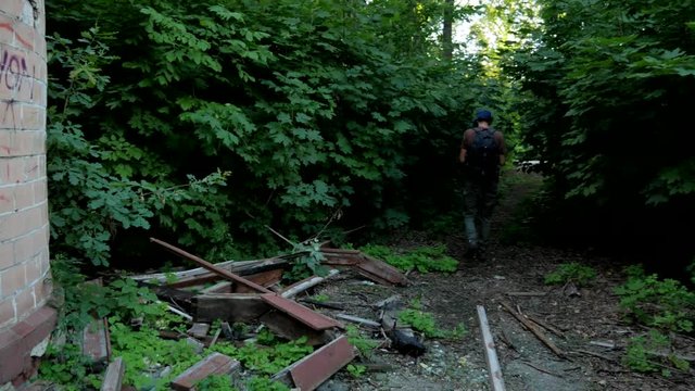 Tourist makes photos of building ruins  and walks through green deep wood 