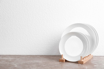 Rack with new ceramic dishware on table