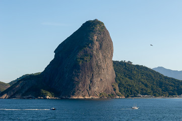 Sugar Loaf, Rio de Janeiro, tourist attraction, back view, a Brazil symbol. Sea, blue sky, boats and stone Pao de Acucar, seen from Niteroi city, located across the Guanabara Bay.